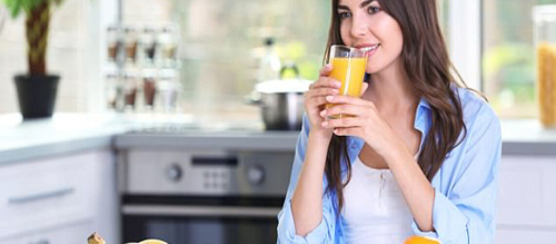 Lady drinking orange juice promoting special discounts on natural supplements